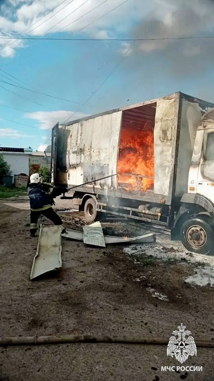 Сотрудник МЧС тушит повреждённый грузовой автомобиль