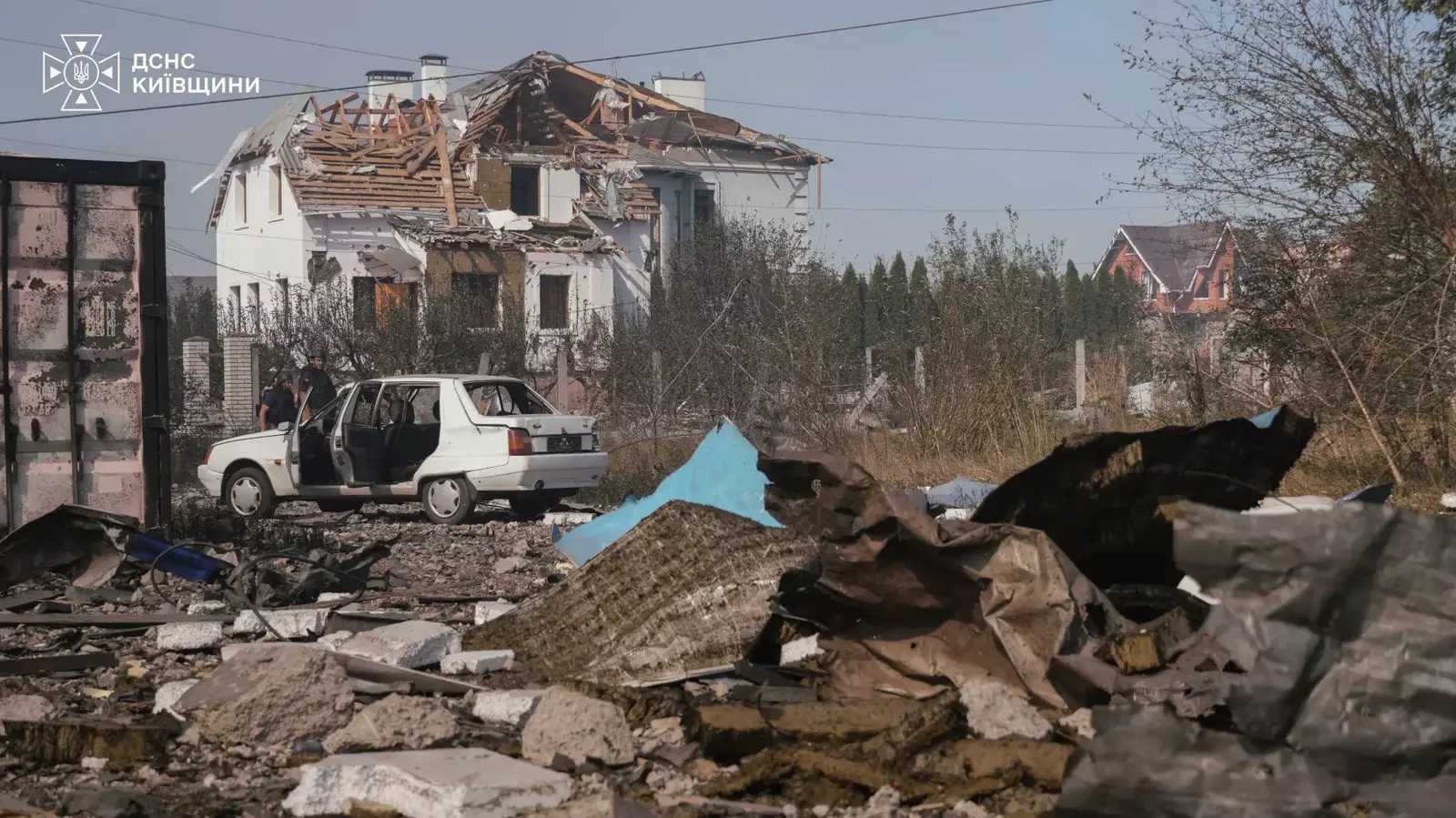 Разрушенная крыша жилого дома, повреждённая машина и обломки в селе Мила после детонации боеприпасов