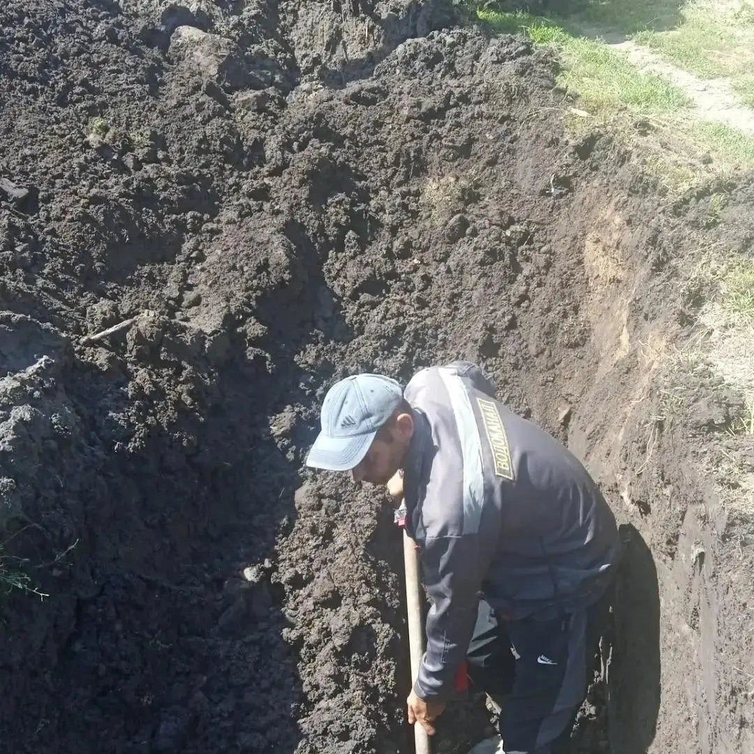 Работник водоканала ремонтирует водопровод в Кременной