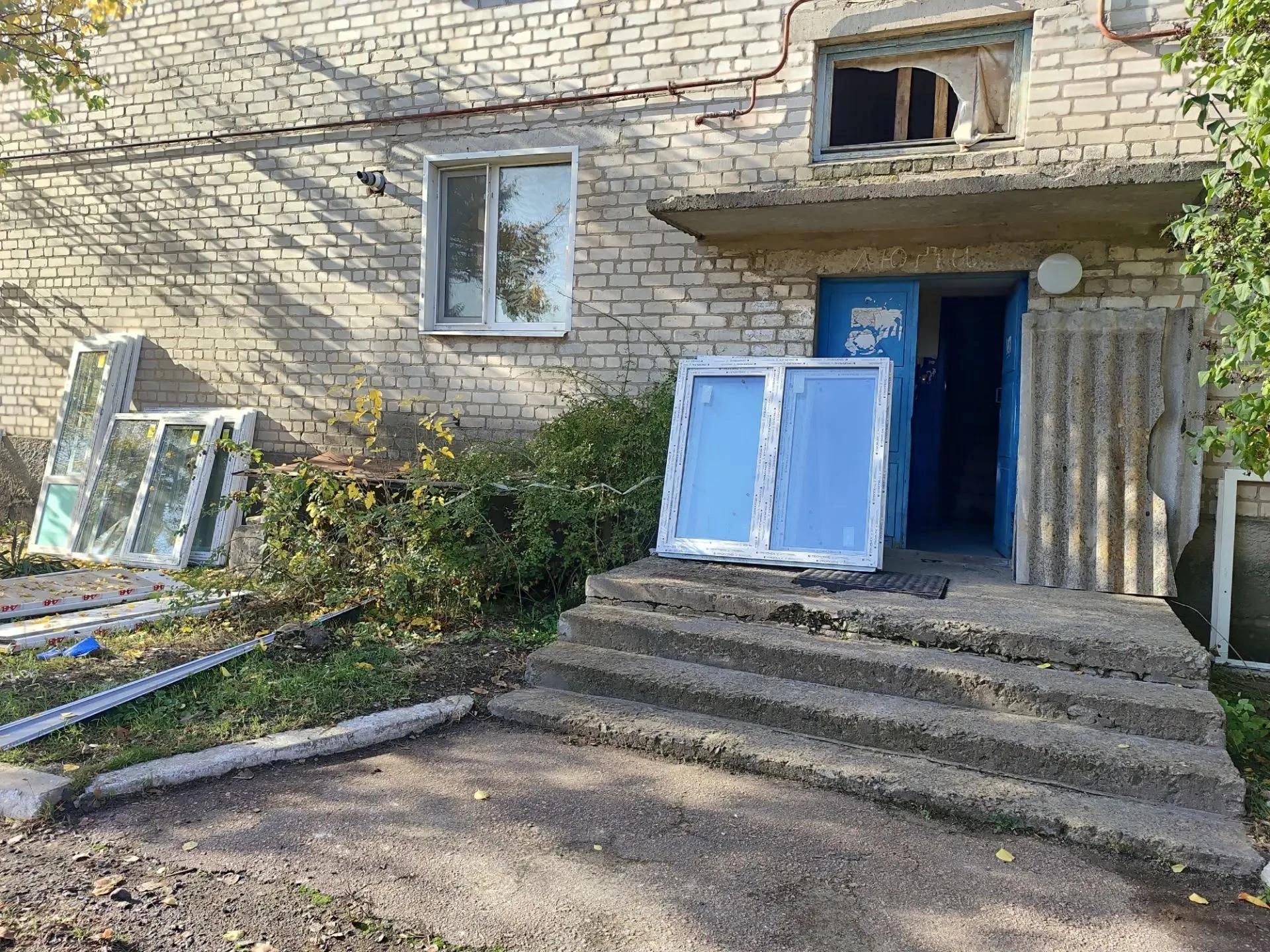 Новые оконные блоки у входа в кирпичное здание
